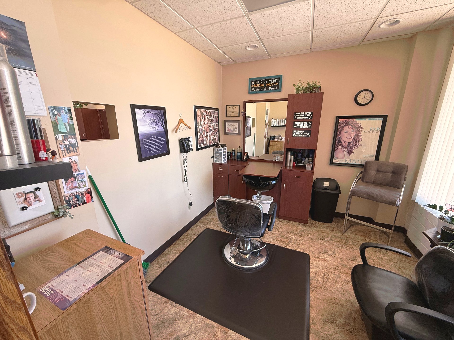 An individual styling station at Clipped Accent with chair, mirror, and warm wood workstation